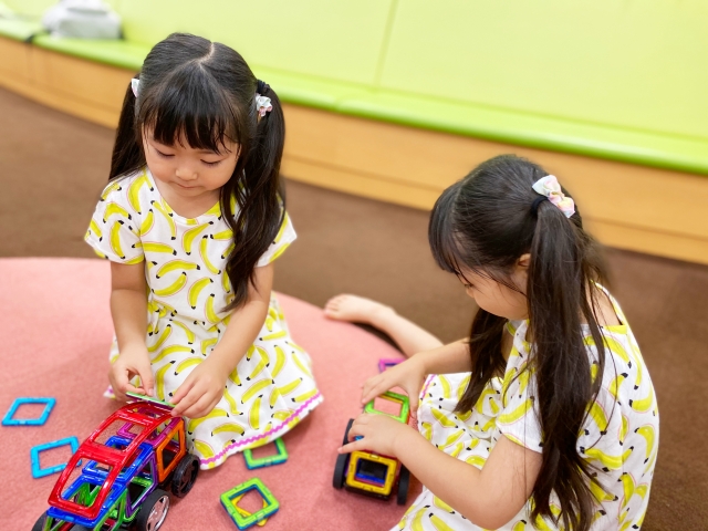 おもちゃで遊ぶ双子の女の子の画像