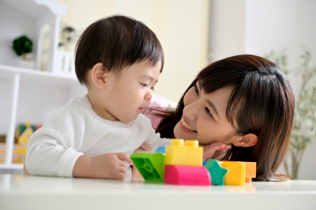 おもちゃで遊ぶ赤ちゃんとお母さんの画像